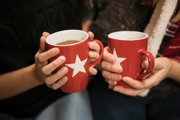 Manos de primer plano con tazas de café