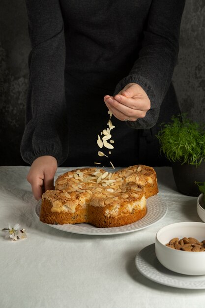 Manos rociando almendras en el pastel