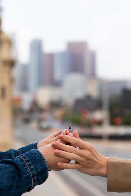 Foto gratuita manos sosteniendo anillo de compromiso