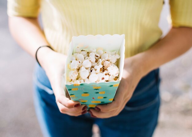 Manos sosteniendo caja de palomitas