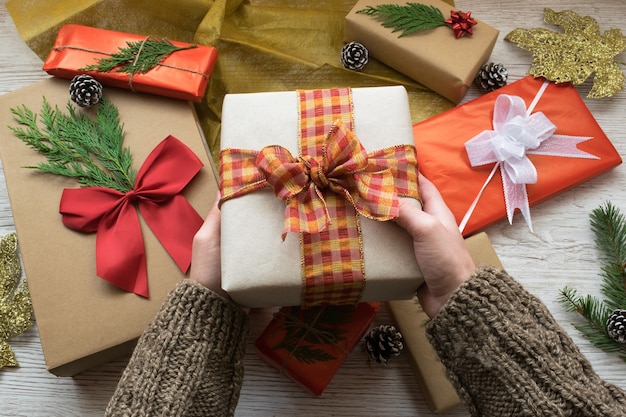 Manos sosteniendo una caja de regalo de Navidad