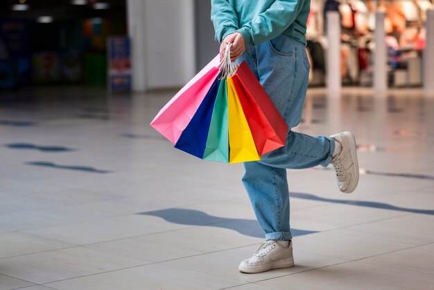 Manos sosteniendo coloridos bolsos de compras