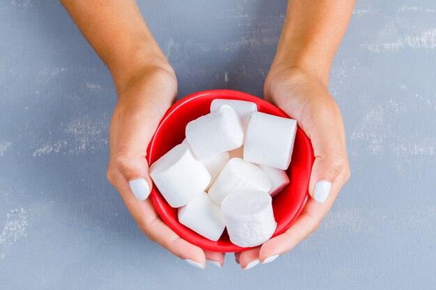 Manos sosteniendo cosas dulces en un tazón