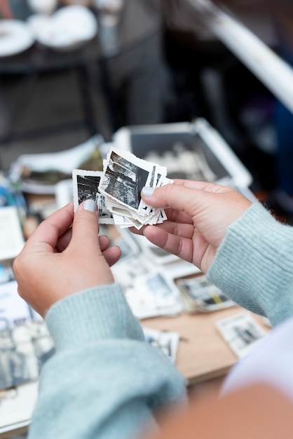 Foto gratuita manos sosteniendo fotos antiguas en el mercado de segunda mano