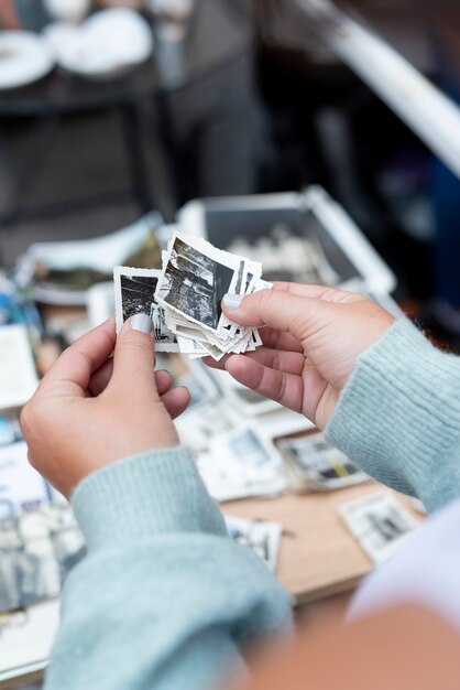 Manos sosteniendo fotos antiguas en el mercado de segunda mano