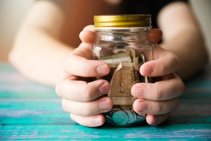 Foto gratuito manos sosteniendo un frasco de ahorros