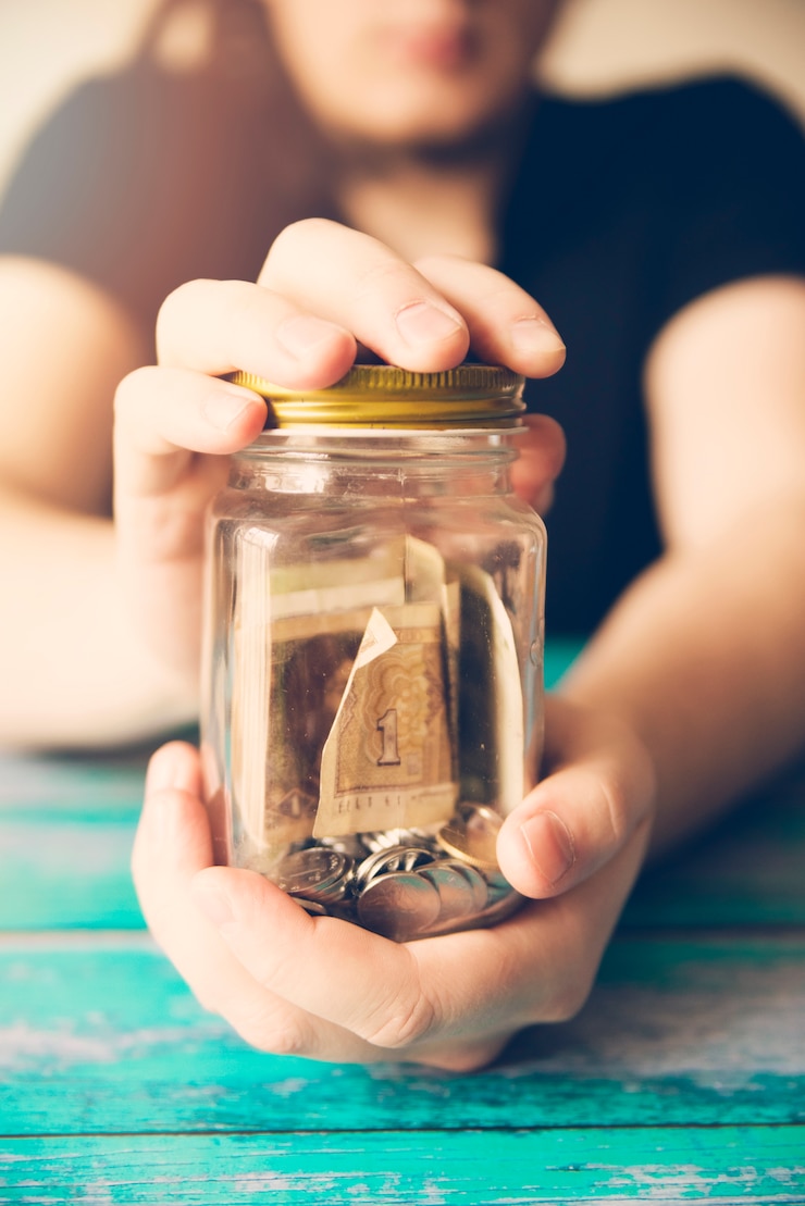 Foto gratuito manos sosteniendo un frasco de ahorros