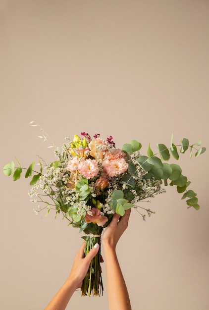 Foto gratuita manos sosteniendo hermosas flores boho