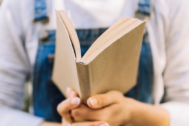 Manos sosteniendo libro abierto