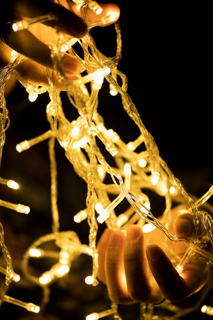 Foto gratuito manos sosteniendo luces de decoración garland
