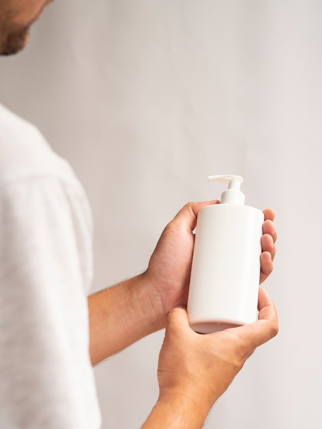 Foto gratuita manos sosteniendo maqueta de botella de loción