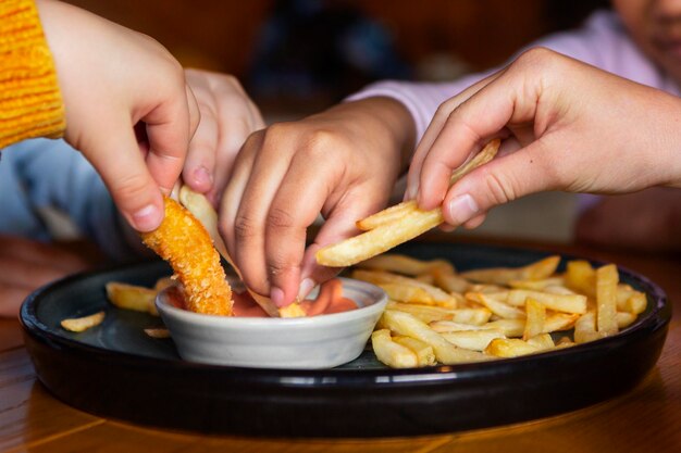 Manos sosteniendo papas fritas de cerca