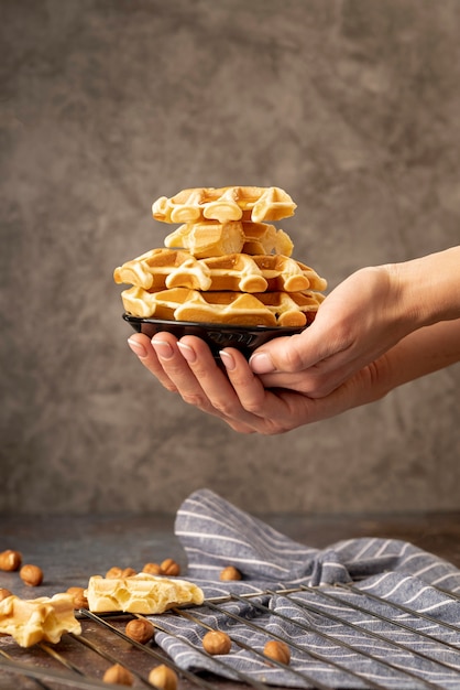 Manos sosteniendo la pila de waffles en placa