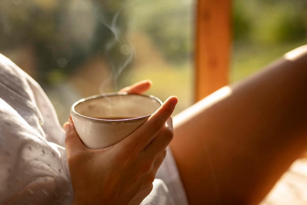 Foto gratuita manos sosteniendo la taza de café de cerca