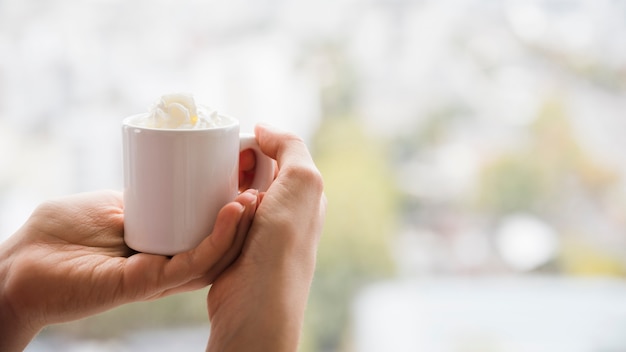 Manos sosteniendo taza de té