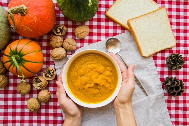 Manos sosteniendo el tazón de puré de calabaza