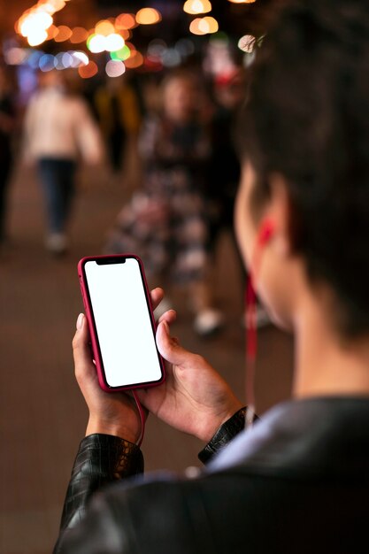 Manos sosteniendo el teléfono inteligente de cerca