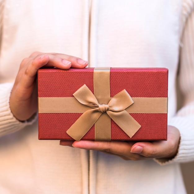 Manos sujetando caja de regalo