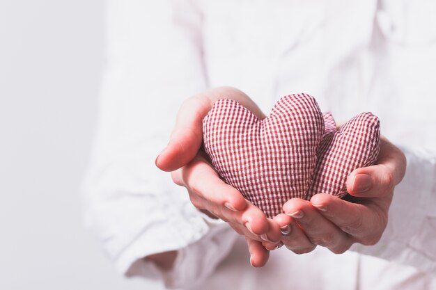 Manos sujetando dos corazones de peluche