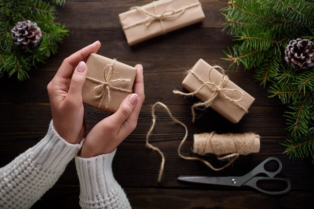 Manos sujetando un regalo marrón