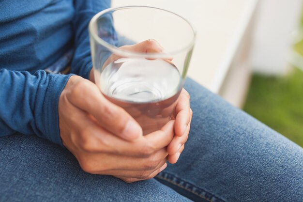 Manos sujetando un vaso con agua