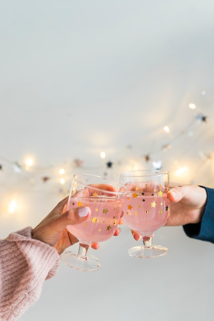 Foto gratuita manos con taza de bebidas cerca de luces de hadas