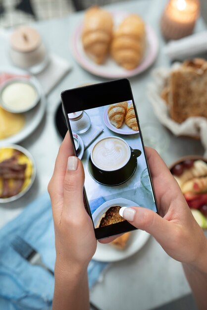 Manos tomando fotos de la taza de café de cerca