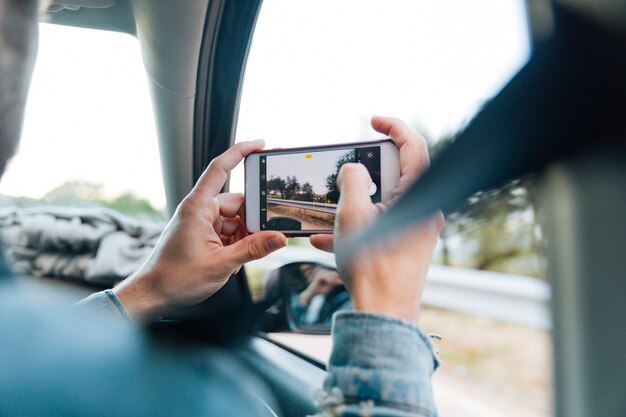 Manos tomando fotos en el teléfono en viaje