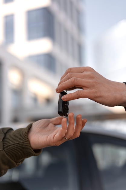 Foto gratuita manos de vista lateral sosteniendo la llave del auto