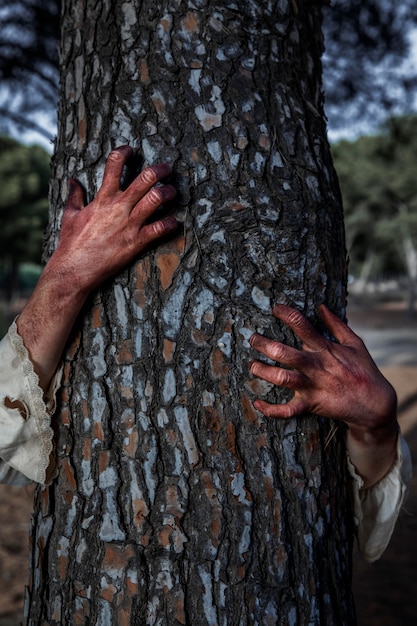 Manos de zombie espeluznante en un árbol