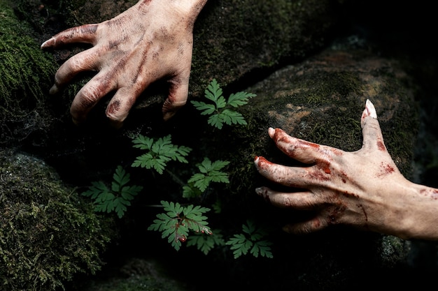 Foto gratuita manos de zombies espeluznantes en la naturaleza