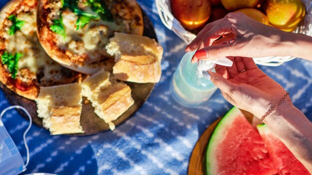 Manta de picnic con golosinas y desinfectante para manos