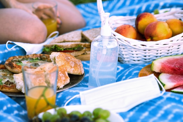 Manta de picnic con golosinas y desinfectante para manos