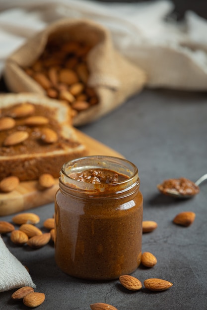 Mantequilla de almendras orgánica cruda sobre fondo oscuro