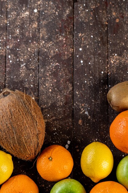 Manzana de coco limón y mandarina en una mesa de madera