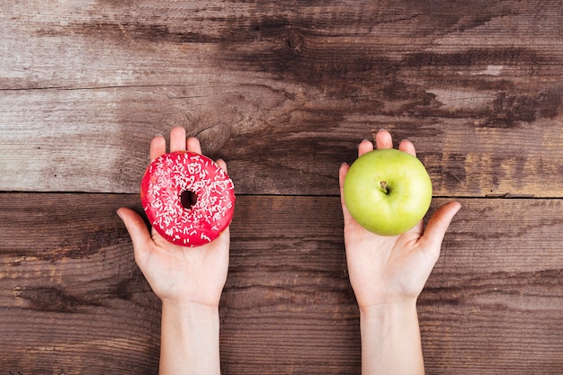 Manzana y donut sobre fondo de madera