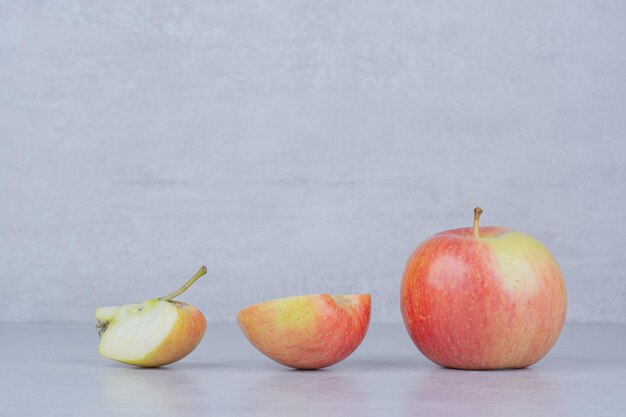 Una manzana entera con rodajas sobre fondo blanco. Foto de alta calidad