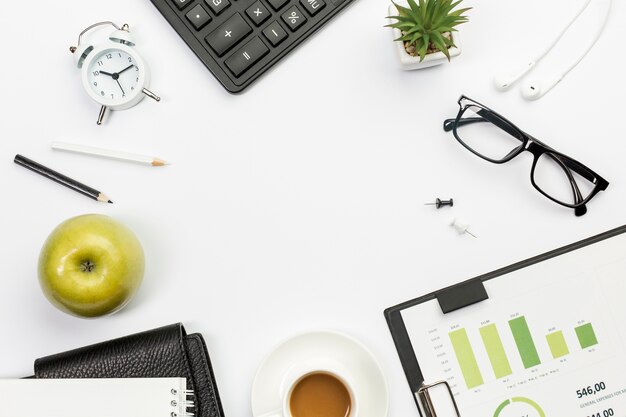 Manzana entera verde con papelería en escritorio de oficina blanco