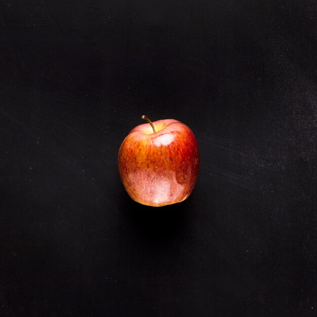 Manzana fresca en escritorio negro