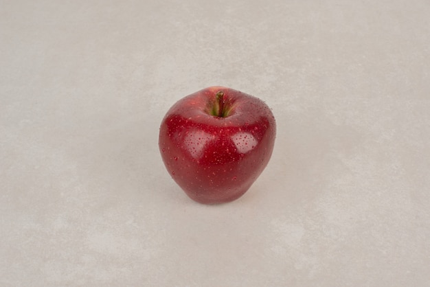 Foto gratuita una manzana roja y fresca en el cuadro blanco.