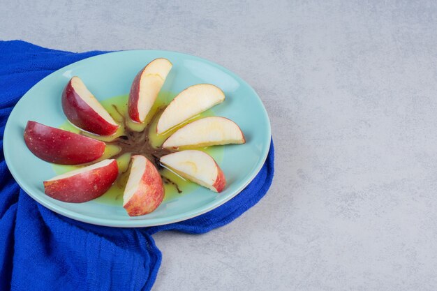 Manzana roja fresca. rodajas en un plato azul.