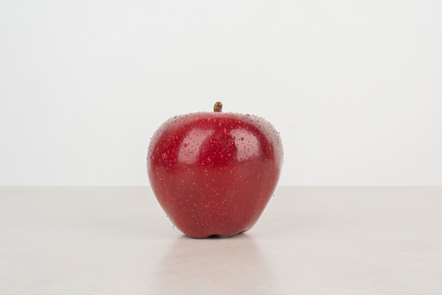 Una manzana roja y fresca sobre fondo blanco.