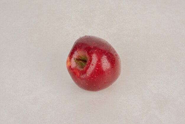 Una manzana roja y fresca sobre fondo blanco.