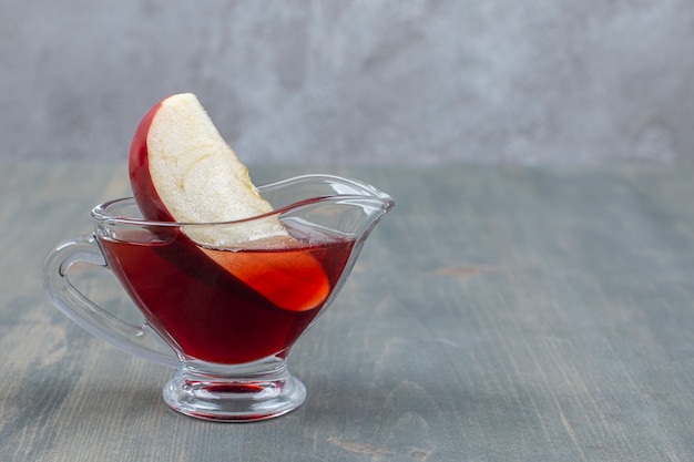 Manzana roja en rodajas y entera con jugo