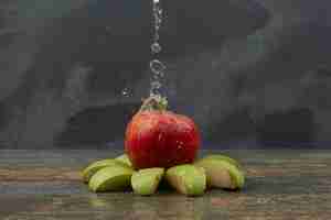 Foto gratuita manzana roja con rodajas de manzana sobre la superficie de mármol.