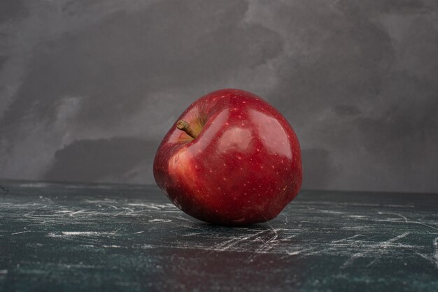 Manzana roja sobre fondo de mármol.