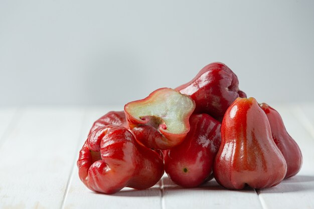 Manzana rosa sobre superficie de madera blanca