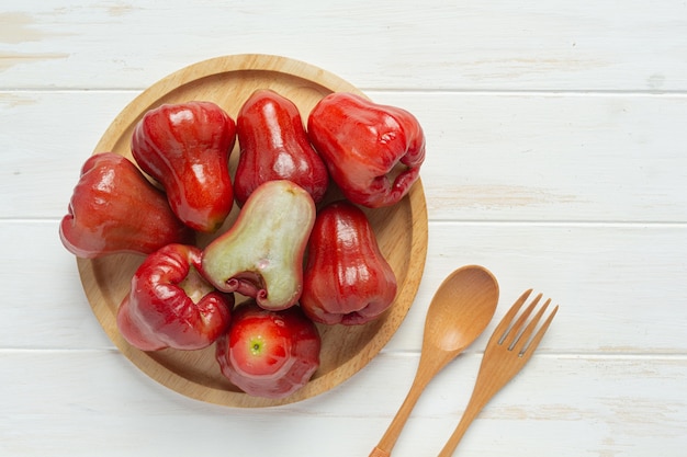 Manzana rosa sobre superficie de madera blanca