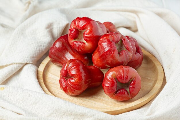 Manzana rosa sobre superficie de madera blanca