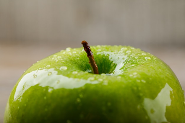 Manzana verde agria sobre un fondo sucio. de cerca.